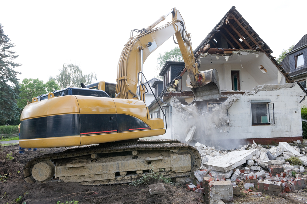 a digger demolishing houses for reconstruction